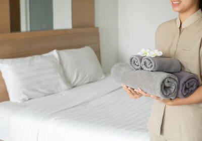 1-stock-photo-hotel-maid-stacked-towels-bed-placed-flowers-towels-hotel-room