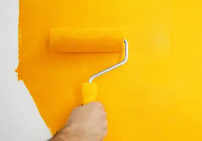 11-stock-photo-man-painting-white-wall-yellow-dye-closeup-interior-renovation
