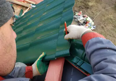 3-stock-photo-worker-installs-attaches-metal-tile-roof-house-2020