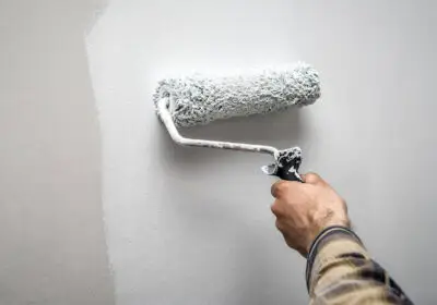 5-stock-photo-hand-holding-paint-roller-while-painting-house-wall-industrial-theme