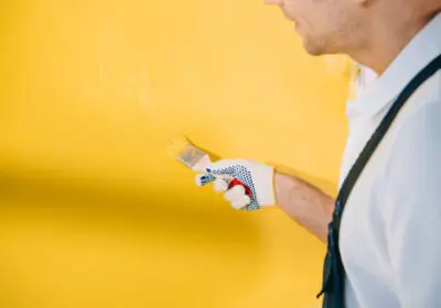 7-stock-photo-cropped-view-young-painter-painting-wall-yellow-color-paintbrush