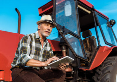 4-stock-photo-senior-farmer-straw-hat-using-digital-tablet-red-tractor-2