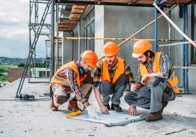 1-stock-photo-close-shot-group-happy-builders-having-conversation-building-plan